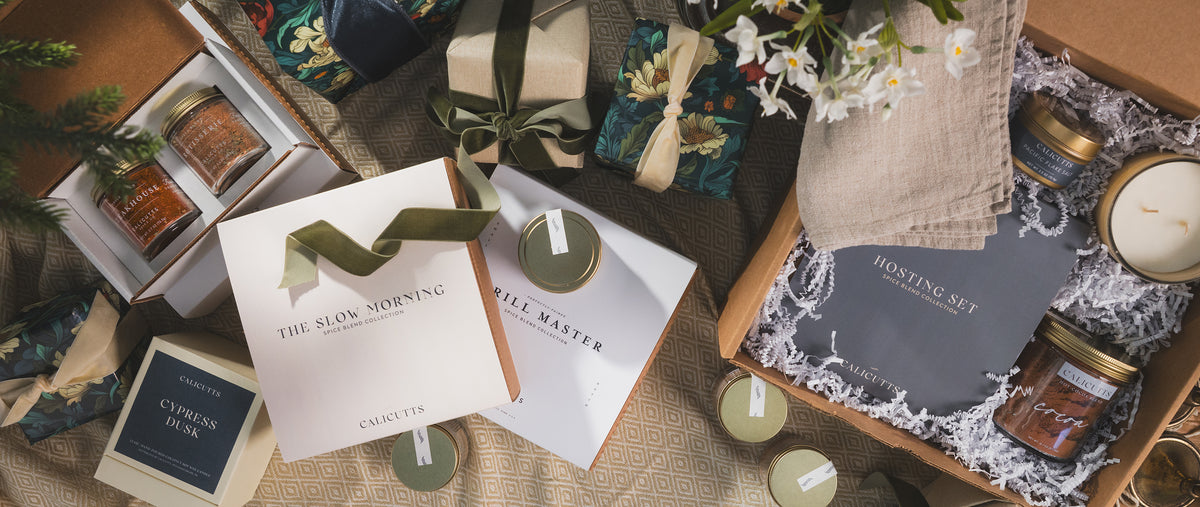 a group of boxes with ribbons and a jar of candles