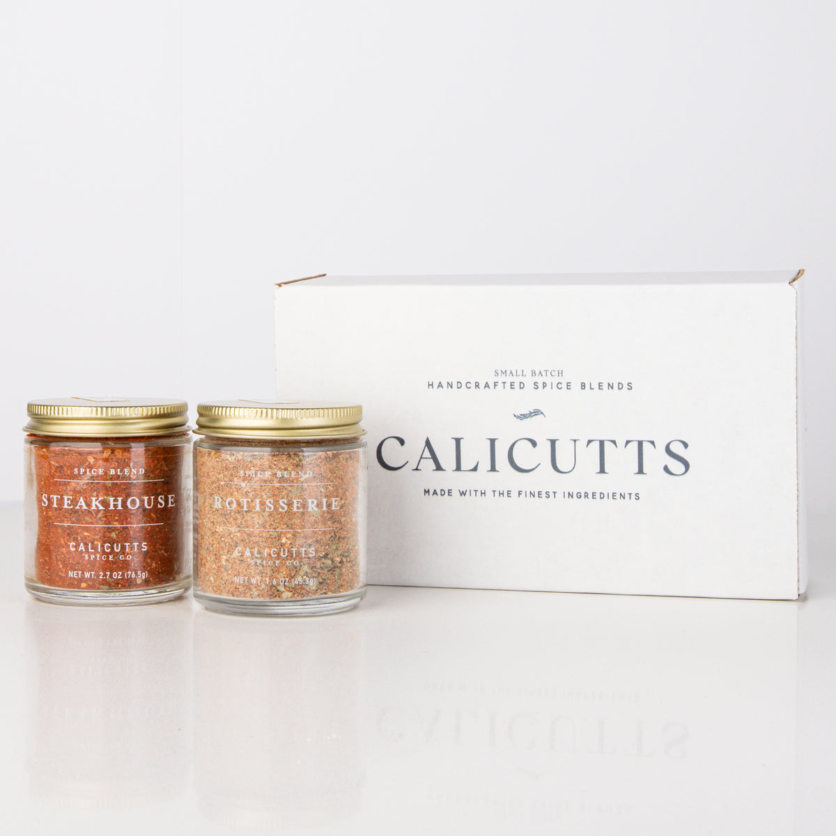 two jars of spices next to a box